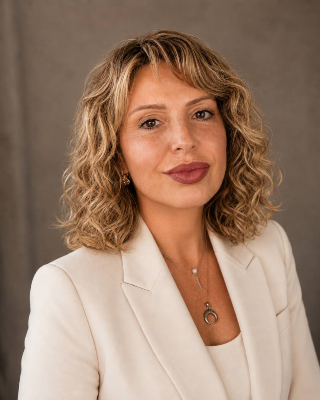 Retrato de Lisbeth Oliveira com blazer creme.